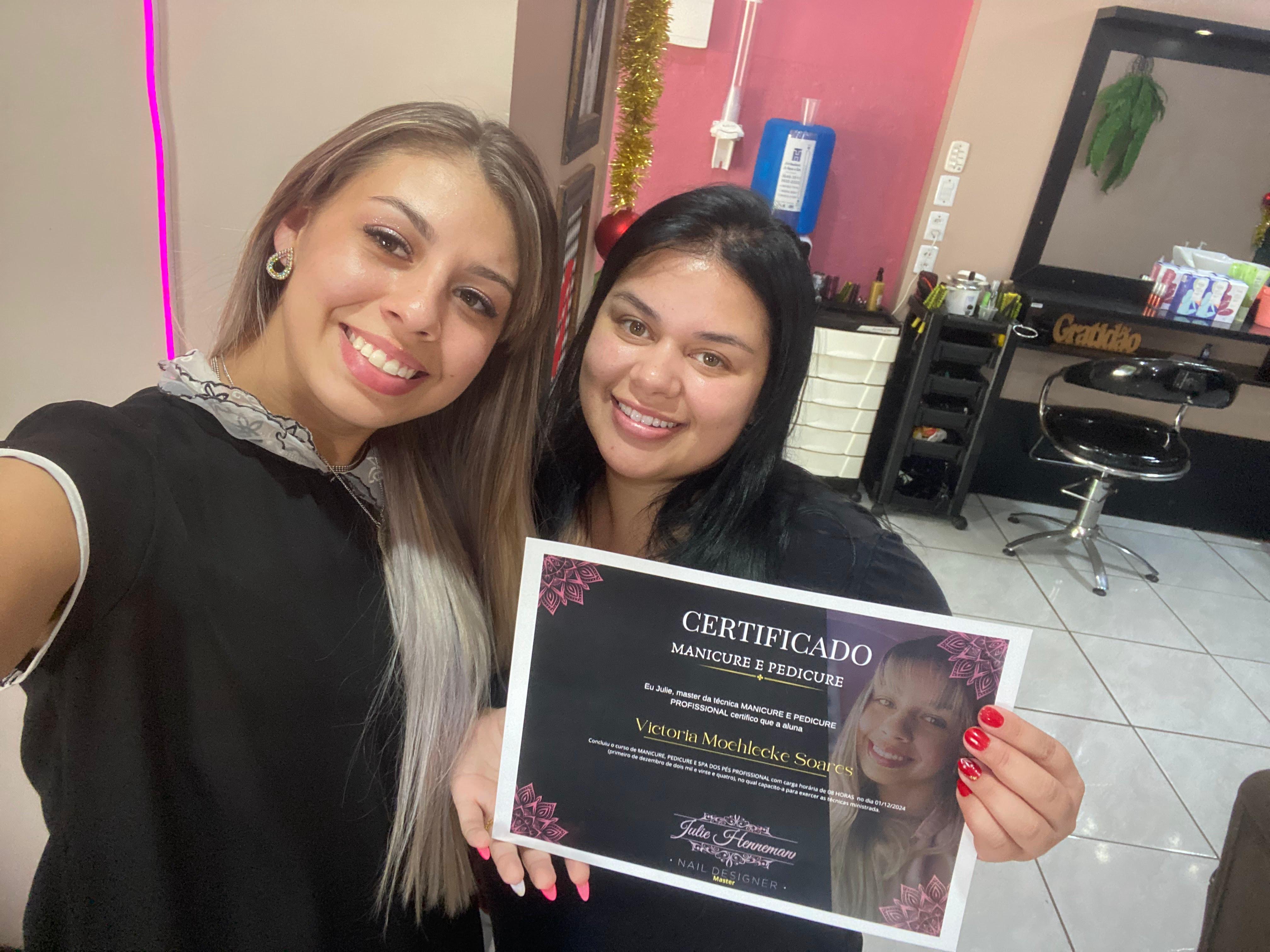Julie com a aluna Victoria segurando o certificado de Manicure e Pedicure