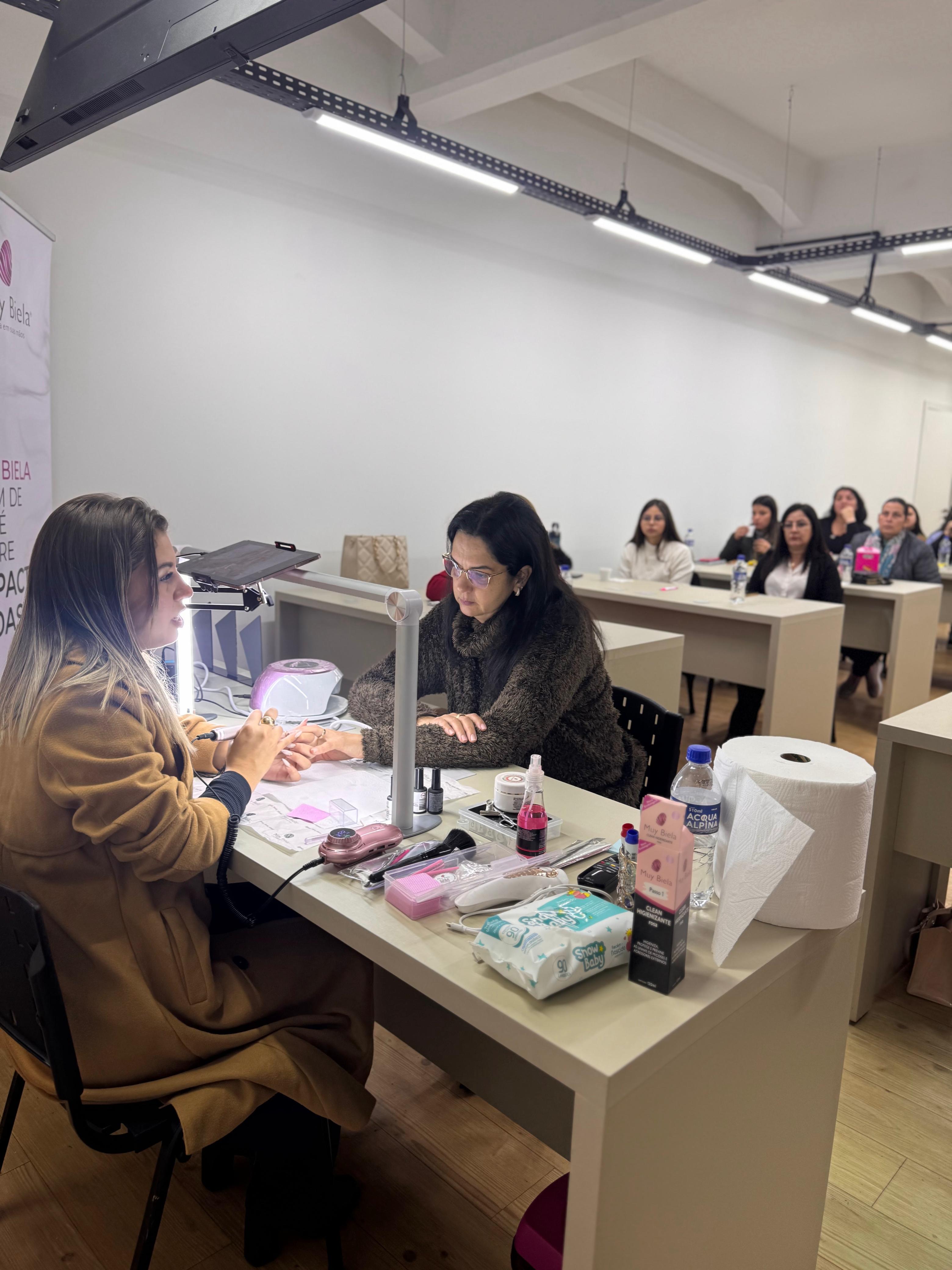 Julie Hennemann fazendo uma demonstração prática de unhas para uma turma em evento
